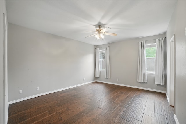 empty room featuring ceiling fan, baseboards, and dark wood-type flooring