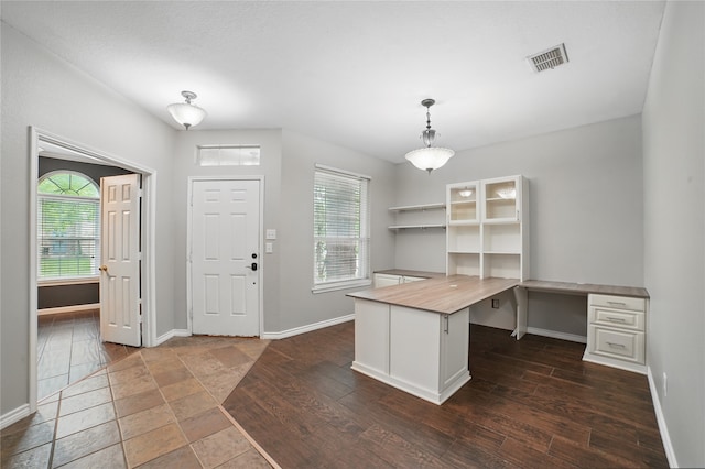 unfurnished office featuring visible vents, baseboards, a wealth of natural light, and dark wood-style floors
