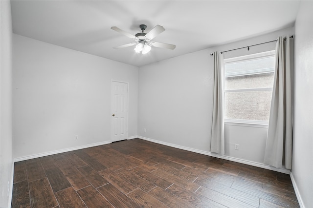 empty room featuring dark wood-style flooring, ceiling fan, and baseboards