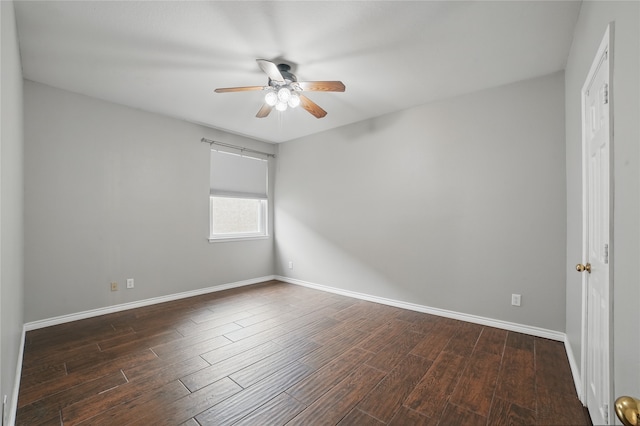 spare room featuring baseboards, ceiling fan, and dark wood-style floors