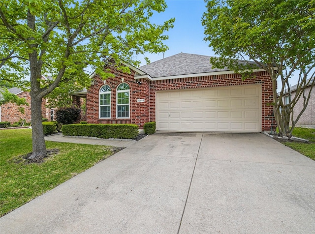 view of front facade featuring a shingled roof, brick siding, a garage, a front yard, and concrete driveway