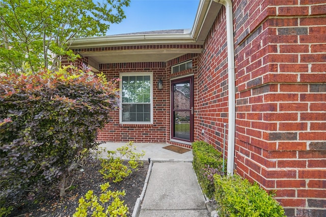 view of exterior entry with brick siding