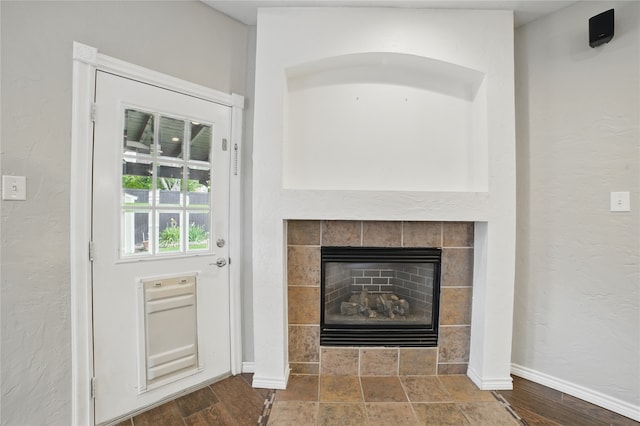room details featuring baseboards and a tile fireplace
