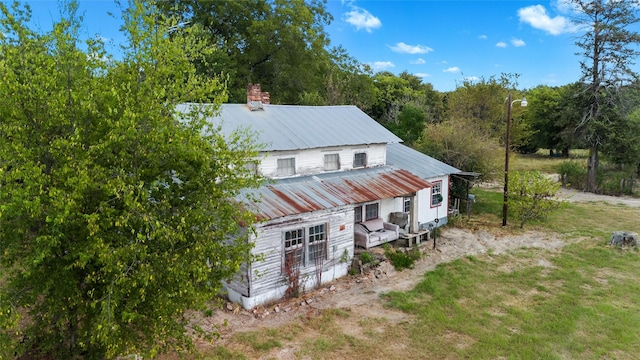 exterior space with metal roof and a chimney