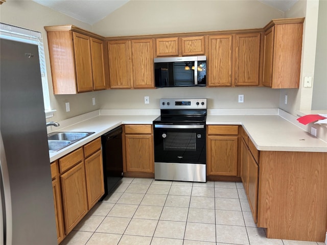 kitchen with a sink, stainless steel appliances, brown cabinets, and lofted ceiling