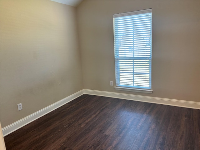 unfurnished room with baseboards and dark wood-style floors