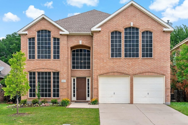 view of front of home with a garage, a front yard, brick siding, a shingled roof, and driveway