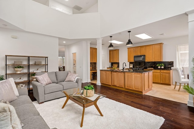 living room featuring visible vents, recessed lighting, dark wood-style flooring, and decorative columns