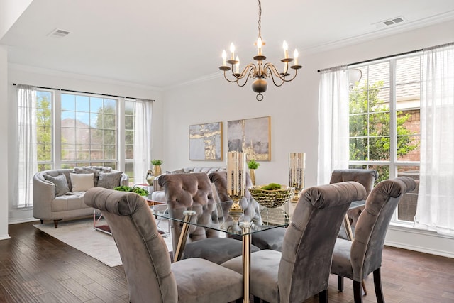 dining room with visible vents, crown molding, wood finished floors, baseboards, and a chandelier