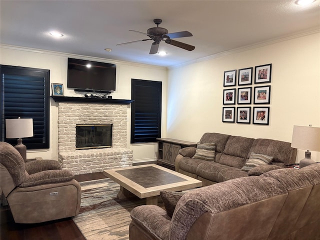 living room featuring crown molding, wood finished floors, a fireplace, and ceiling fan