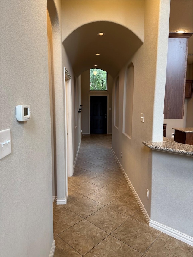 1121 Albany Dr, Fort Worth, TX 76131 - hall with arched walkways, baseboards, vaulted ceiling, and tile patterned floors