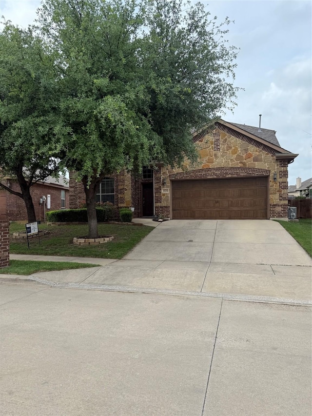 1121 Albany Dr, Fort Worth, TX 76131 - view of front of home with a garage, driveway, and stone siding