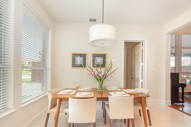 dining space featuring baseboards, visible vents, a healthy amount of sunlight, and light tile patterned floors