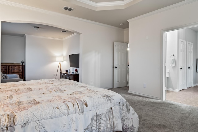 carpeted bedroom featuring crown molding, arched walkways, baseboards, and visible vents