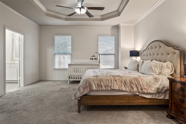bedroom with crown molding, carpet flooring, a raised ceiling, and ensuite bathroom