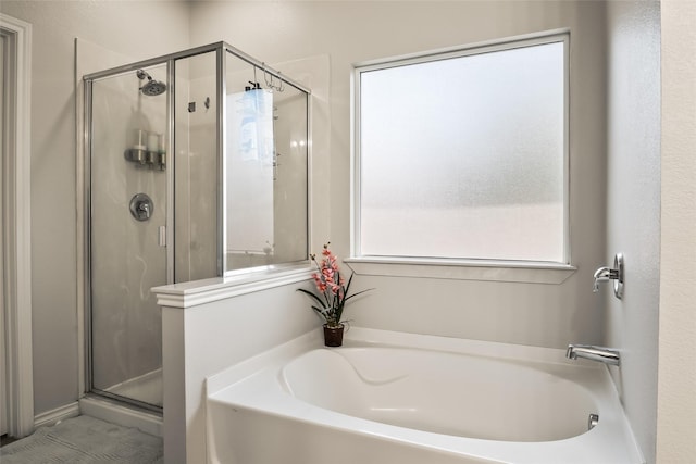 full bathroom with a stall shower and a bath