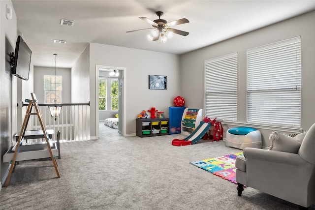 playroom featuring carpet flooring, a ceiling fan, baseboards, and visible vents