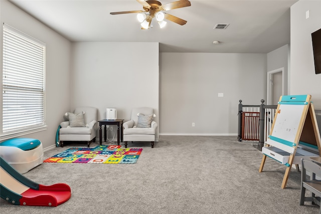 playroom with a wealth of natural light, a ceiling fan, carpet flooring, and visible vents
