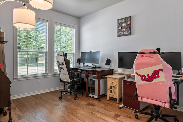 home office with plenty of natural light, baseboards, and wood finished floors
