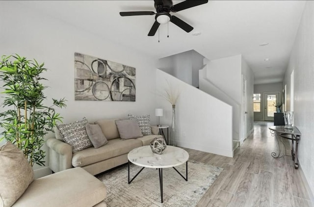 living room with baseboards, ceiling fan, and wood finished floors