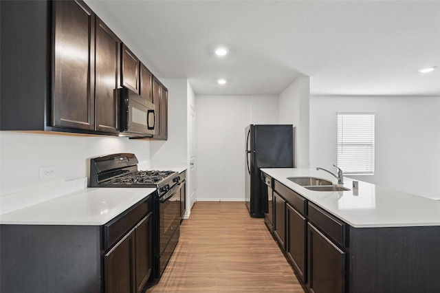 329 Blue Crow Ln, Fort Worth, TX 76052 - kitchen with light countertops, light wood finished floors, a sink, and black appliances