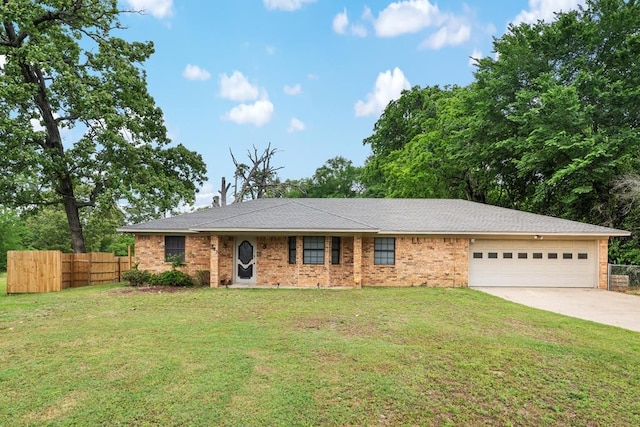 ranch-style home featuring a garage, fence, driveway, and a front yard