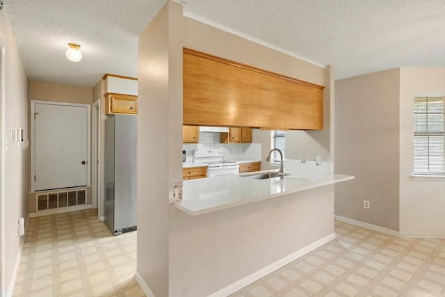 kitchen featuring white range with electric stovetop, a sink, freestanding refrigerator, light floors, and visible vents
