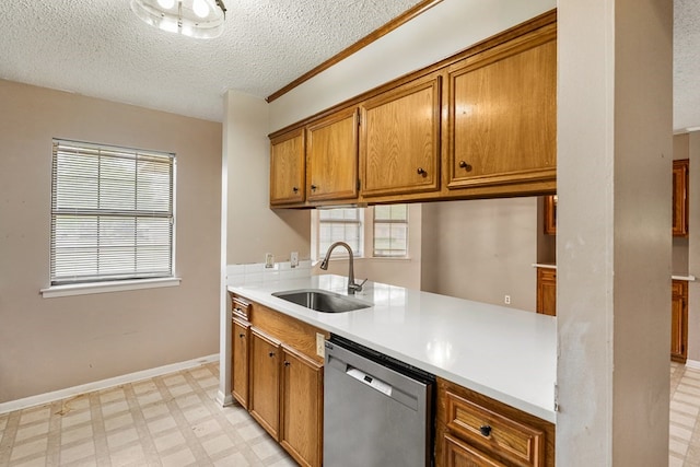 kitchen featuring brown cabinetry, a textured ceiling, dishwasher, a sink, and light floors