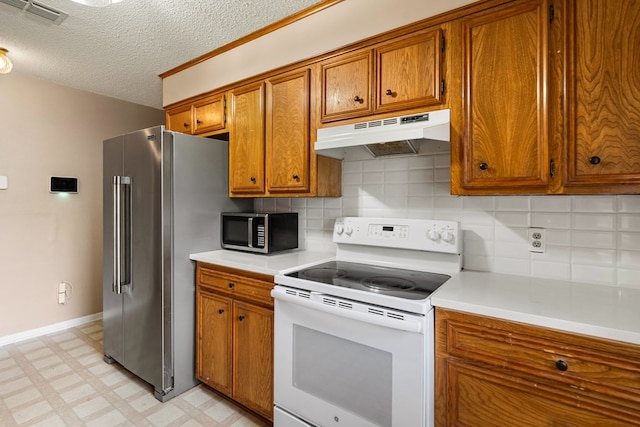 kitchen featuring brown cabinetry, visible vents, light countertops, under cabinet range hood, and stainless steel appliances