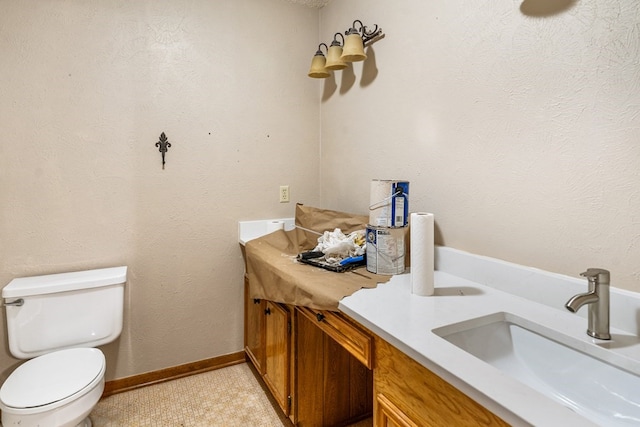 bathroom featuring double vanity, a sink, and toilet