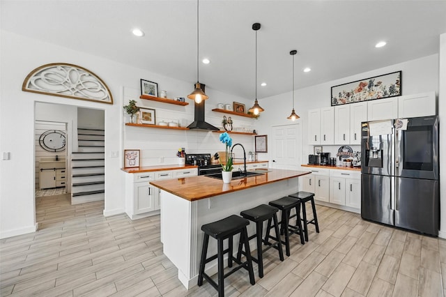 kitchen featuring open shelves, butcher block countertops, white cabinets, stainless steel fridge with ice dispenser, and a sink