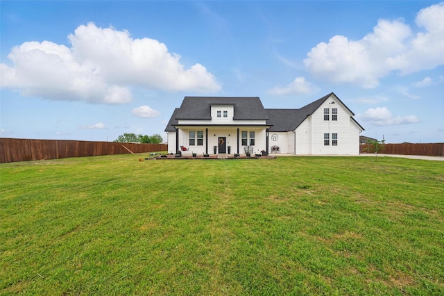 modern inspired farmhouse featuring a porch, fence, and a front lawn