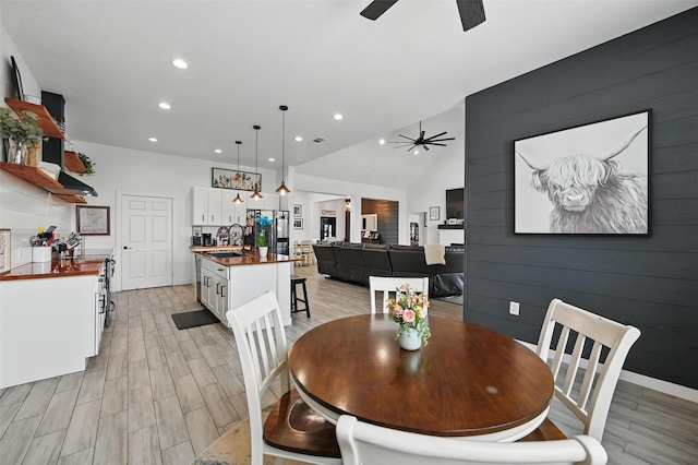 dining area with recessed lighting, ceiling fan, light wood-type flooring, and lofted ceiling