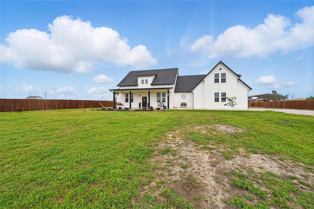 modern farmhouse with a porch, a fenced backyard, a detached carport, and a front lawn