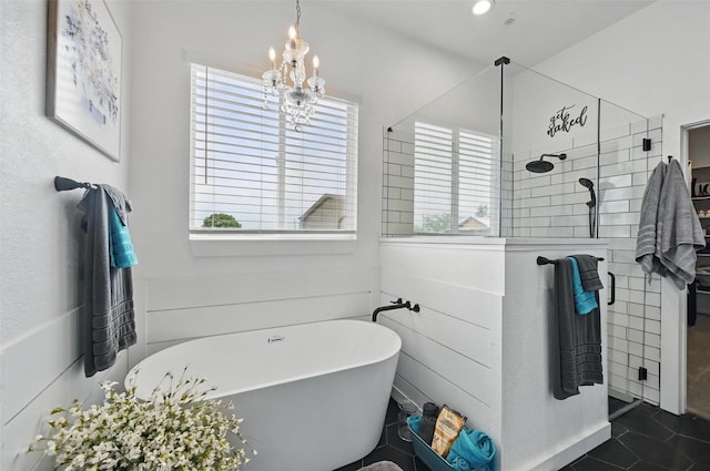bathroom featuring tile patterned flooring, a soaking tub, walk in shower, and a chandelier