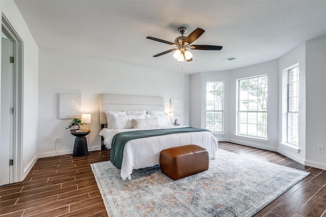 bedroom featuring baseboards, visible vents, ceiling fan, and wood tiled floor