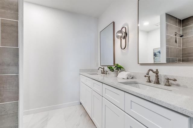 bathroom featuring double vanity, baseboards, a sink, and marble finish floor