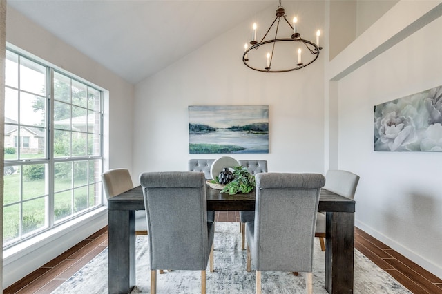 dining space featuring high vaulted ceiling, an inviting chandelier, a wealth of natural light, and wood finished floors
