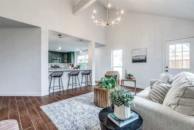 living room with an inviting chandelier, baseboards, dark wood-style floors, and high vaulted ceiling