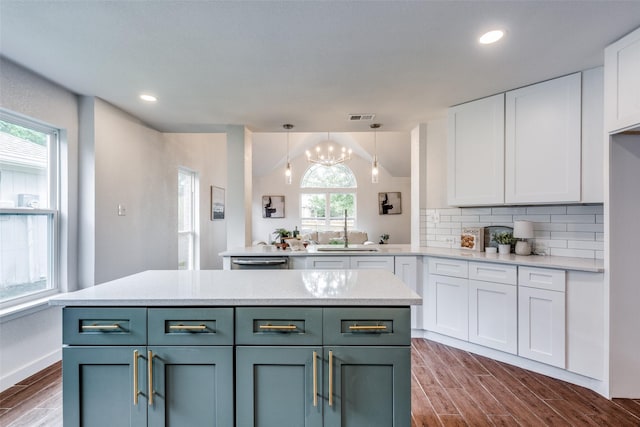 kitchen with white cabinets, dark wood-style flooring, light countertops, backsplash, and visible vents