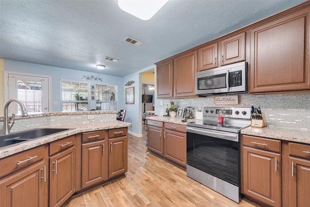 kitchen featuring visible vents, a sink, appliances with stainless steel finishes, and tasteful backsplash