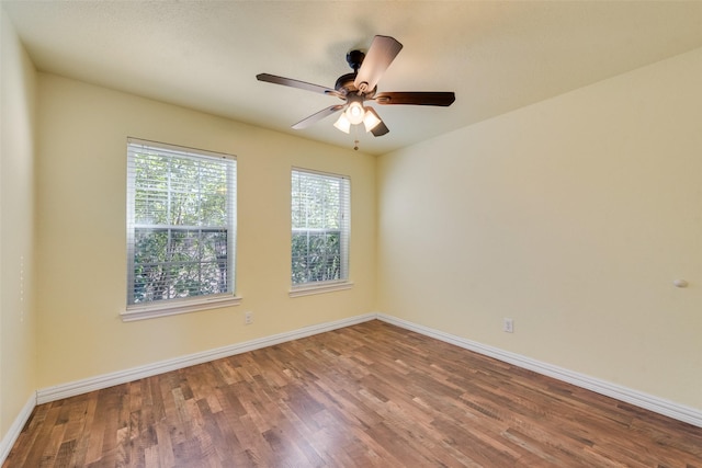 spare room with baseboards, a ceiling fan, and wood finished floors