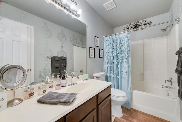 bathroom with vanity, visible vents, wood finished floors, shower / bath combination with curtain, and toilet