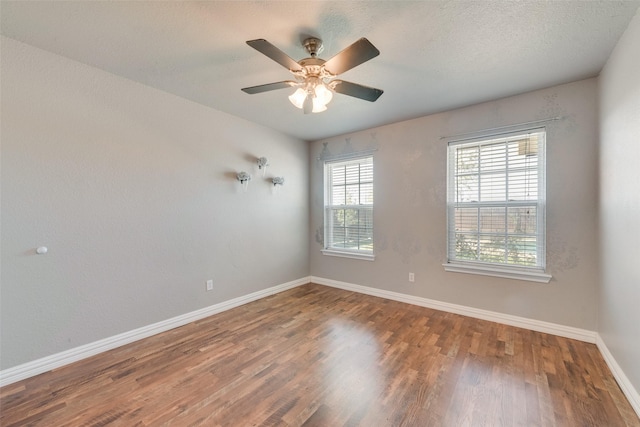 unfurnished room with a textured ceiling, baseboards, ceiling fan, and wood finished floors