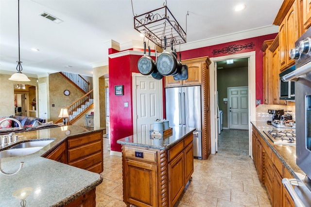kitchen featuring crown molding, a sink, stainless steel appliances, a kitchen island, and visible vents