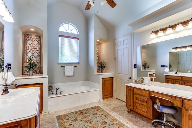 bathroom featuring a sink, a ceiling fan, two vanities, vaulted ceiling, and a garden tub