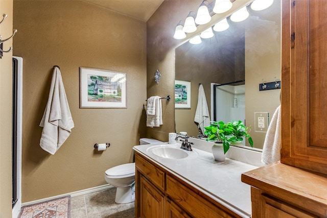 bathroom featuring baseboards, vanity, toilet, and a shower stall