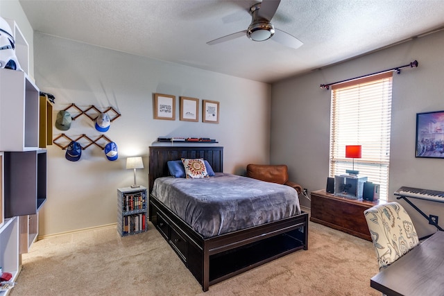 bedroom with ceiling fan, carpet, and a textured ceiling