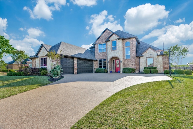french provincial home with a garage, a front yard, roof with shingles, brick siding, and concrete driveway