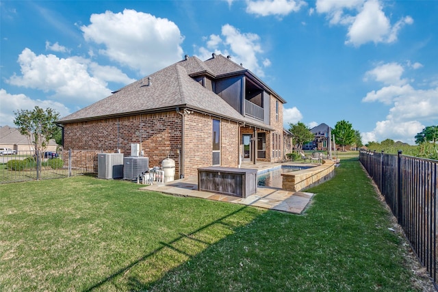 back of house with a shingled roof, central AC, brick siding, a fenced backyard, and a yard